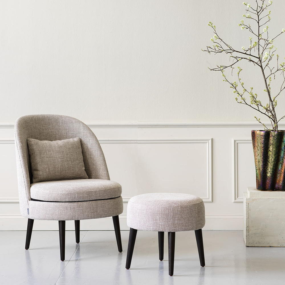 Noote Lounge är en stilren fåtölj tillverkad i massiv bok med klädd sits och rygg.